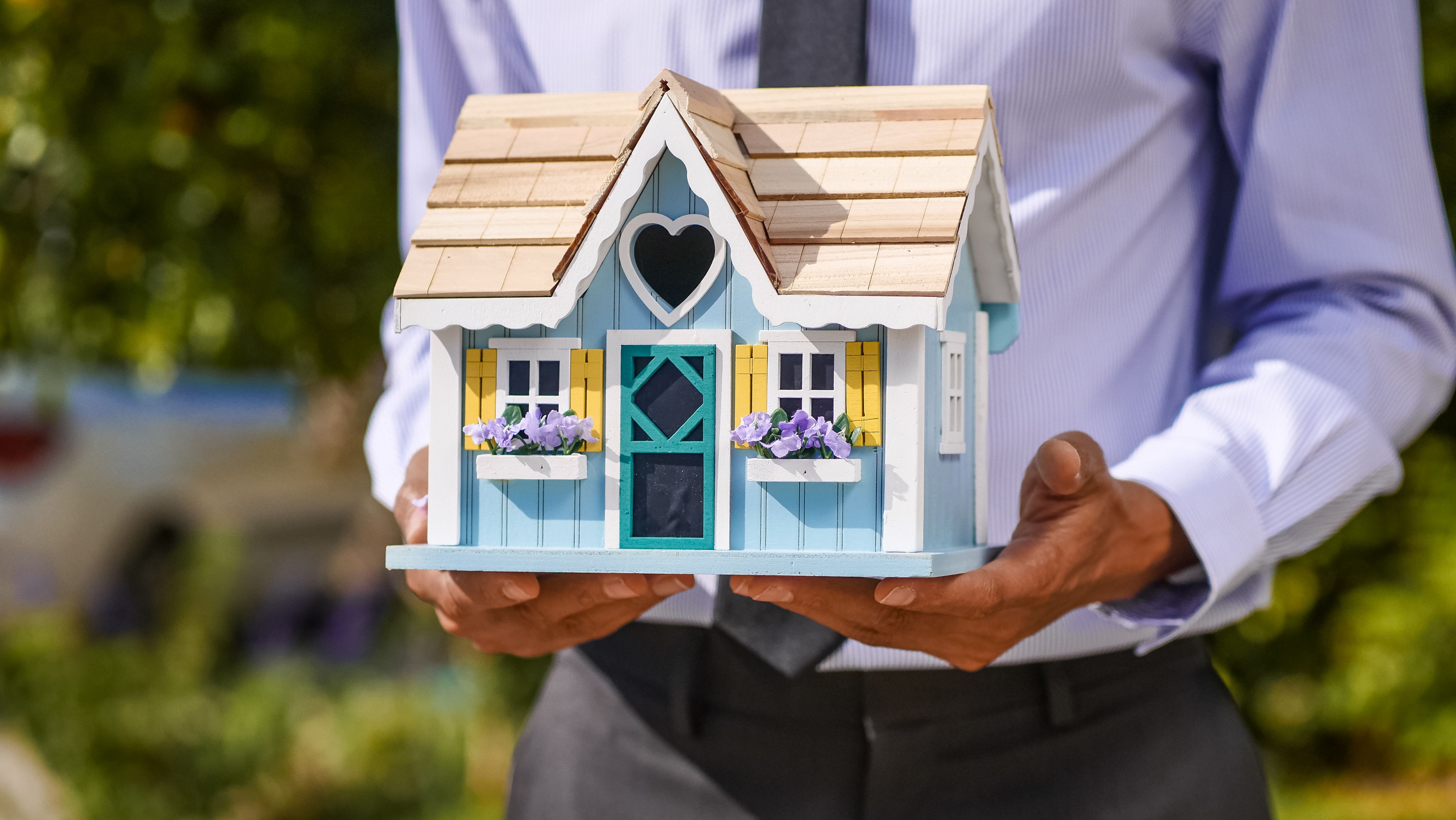 A homeowner holding a small model house